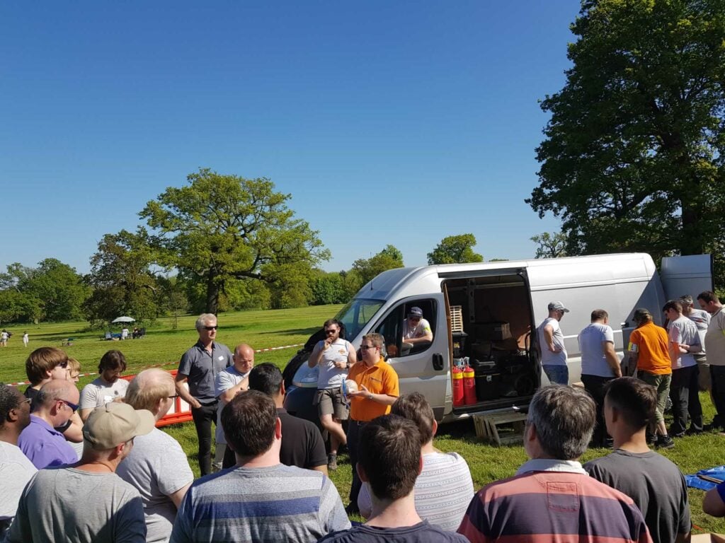 fireworks being unloaded from van whilst talk is being given to watching group