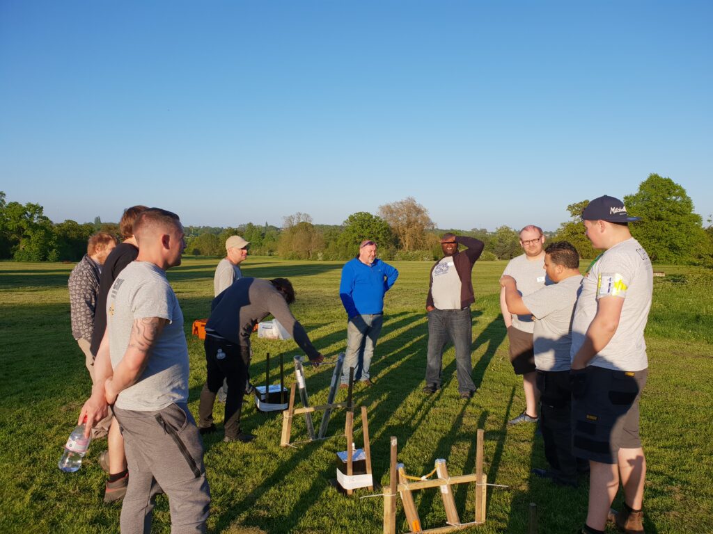 men surrounding row of unlit fireworks
