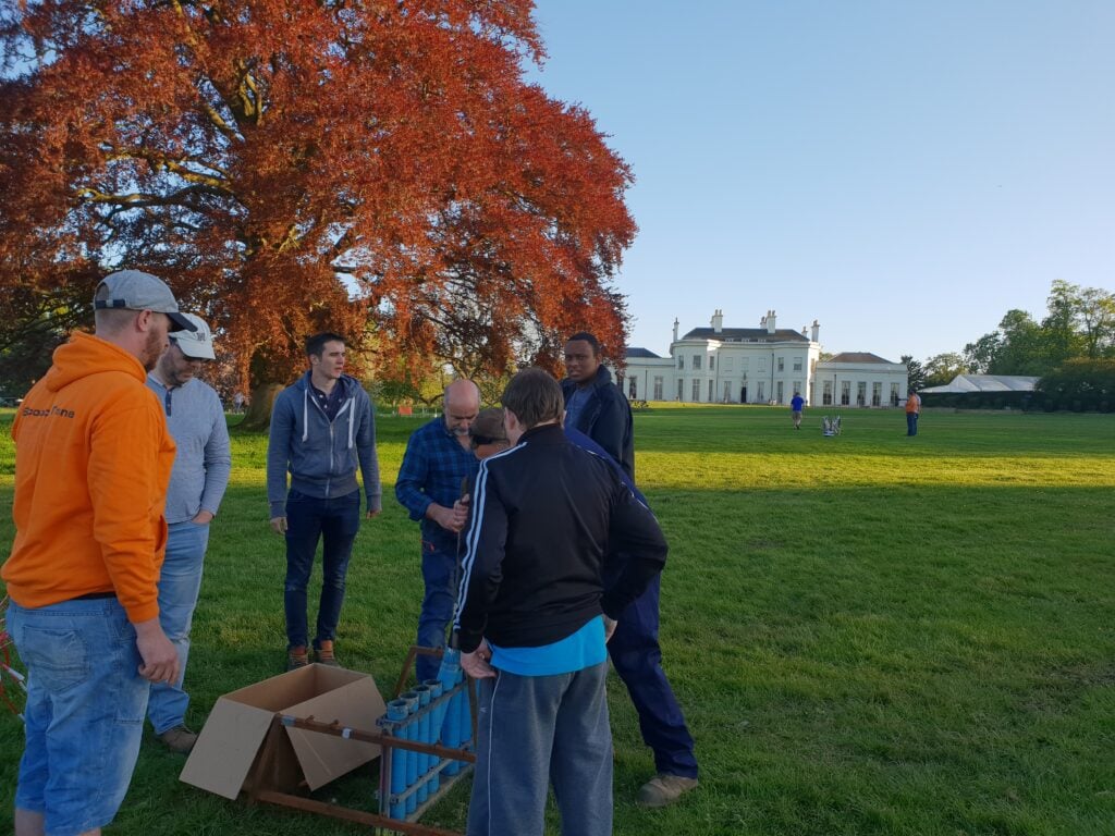 men standing around firework display being set up