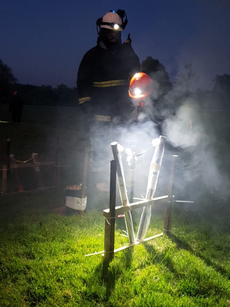 men dressed in PPE igniting fireworks
