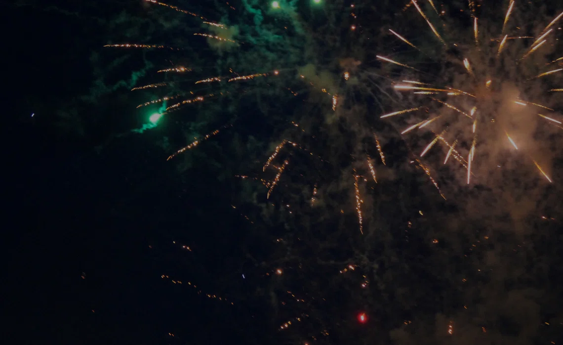 gold and green fireworks in night sky