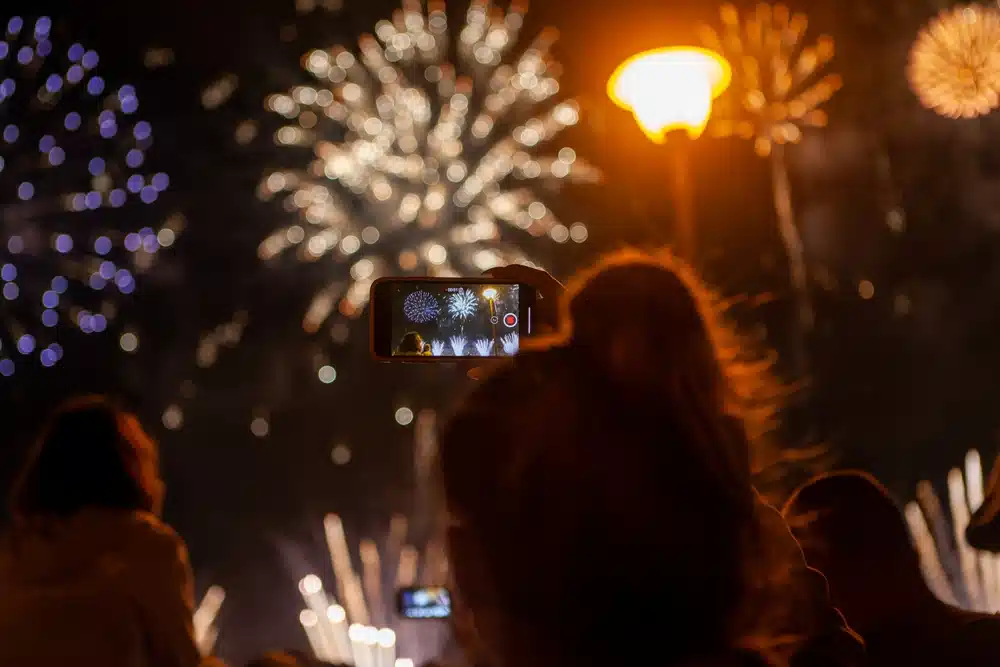 person taking images of fireworks with their phone camera