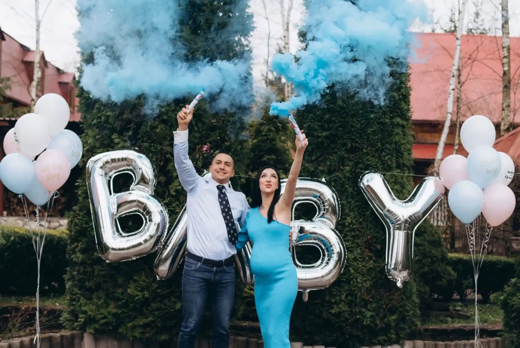 Couple holding blue gender reveal smoke flares